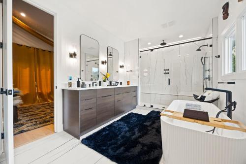 ein Badezimmer mit Badewanne, Waschbecken und Spiegel in der Unterkunft Luxury Home 4BR 4BA City Views HotTub GameRoom in Atlanta