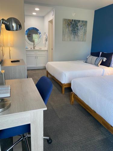 a room with two beds and a desk and a table at Christian Retreat Conference Center in Bradenton