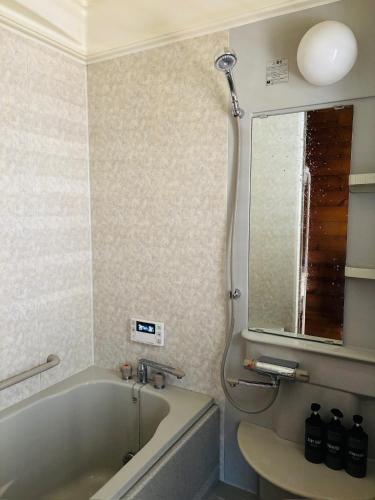 a bathroom with a tub and a sink and a mirror at ISE Family Cabin in Ise