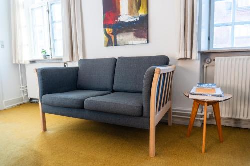 a living room with a blue couch and a table at Palads Hotel in Viborg