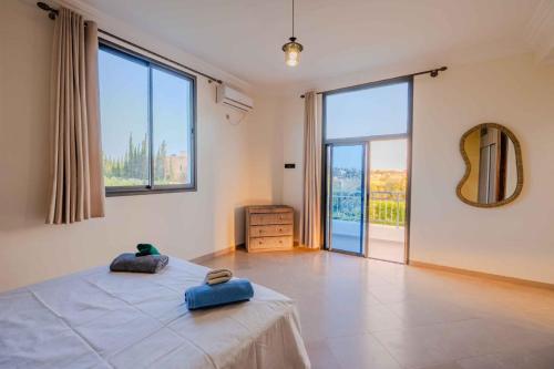 une chambre avec un grand lit et de grandes fenêtres dans l'établissement Villa Tilila Mogador, à Essaouira