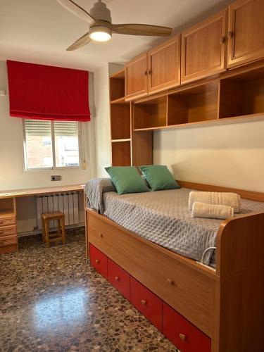 a bedroom with a large bed with wooden cabinets at Apartamento Aljibe Maracena con parking gratis in Maracena