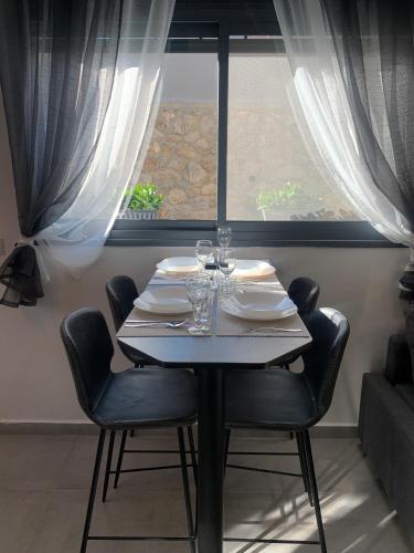 a dining room table with chairs and a window at Via Arad Apartments in Arad