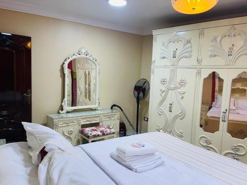 a bedroom with a white bed and a large mirror at B&KHOME Banha in Banī Ghālib