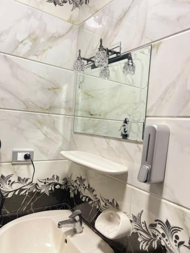 a bathroom with a sink and a mirror at B&KHOME Banha in Banī Ghālib