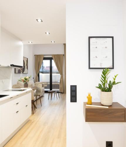 a kitchen and living room with white cabinets at Dorian Suites in Monforte de Lemos