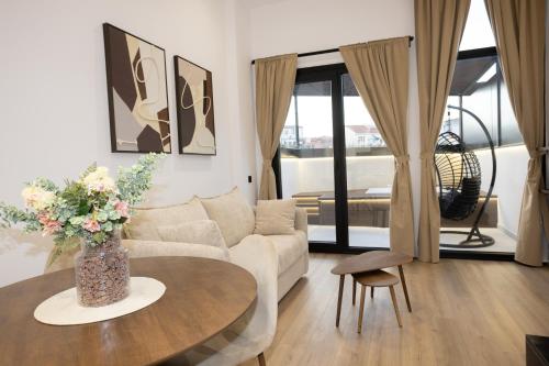 a living room with a couch and a table with flowers at Dorian Suites in Monforte de Lemos
