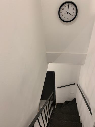 a clock on a wall above a stair case at Via Arad Apartments in Arad