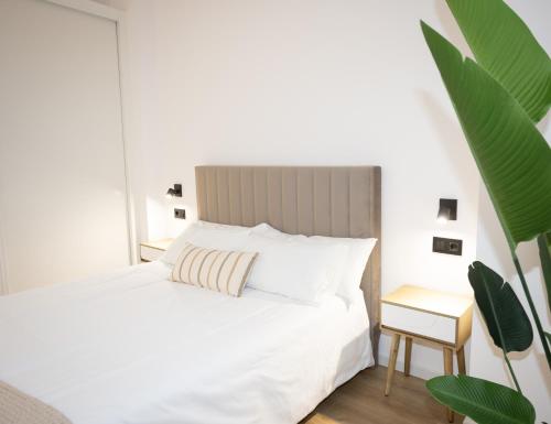 a bedroom with a white bed and a side table at Dorian Suites in Monforte de Lemos