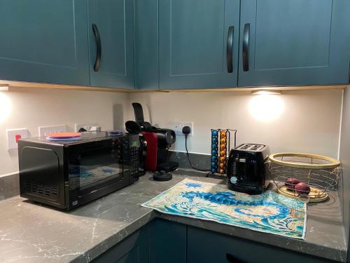 a kitchen counter with a microwave on a counter top at Spacious Private Room - Small Animals Welcomed in Tamworth
