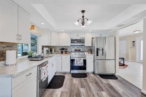 a kitchen with white cabinets and a refrigerator at Heated pool 3 mins Sister Spring in Crystal River