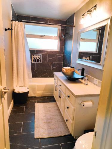 a bathroom with a sink and a toilet and a tub at Old Fig House - Historic Fig Garden Neighborhood in Fresno