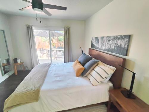 a bedroom with a bed with pillows and a ceiling fan at Old Fig House - Historic Fig Garden Neighborhood in Fresno