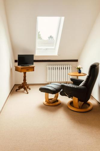 ショルフハイデにあるNaturidylle mit Kamin und Sauna in der Schorfheideの椅子2脚、デスク、窓が備わる客室です。