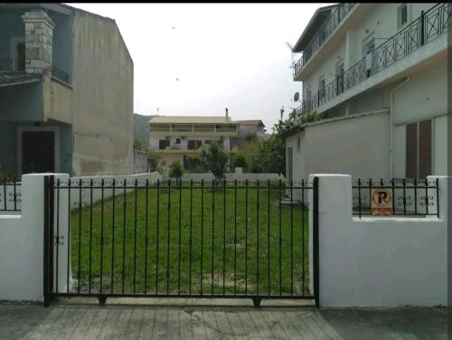 a gate in front of a building with a yard at Sea Side Apartment Plataria in Plataria