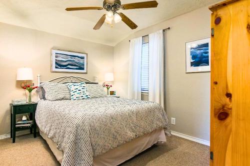 a bedroom with a bed and a ceiling fan at Charming Green Riverfront Stay, New Braunfels in New Braunfels