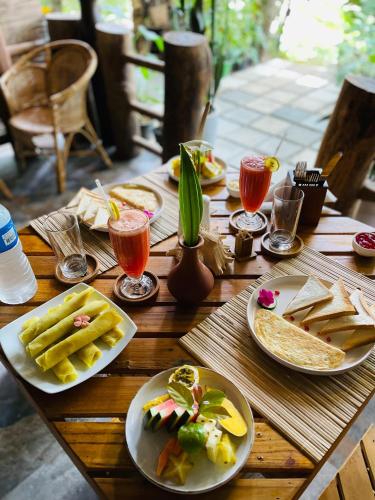 a wooden table with plates of food and drinks on it at La Casa Bella in Ella