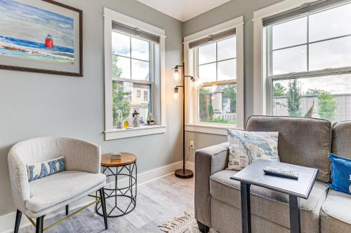 a living room with a couch and a chair and windows at Walk to Dtwn Charlevoix Condo with Fireplace in Charlevoix