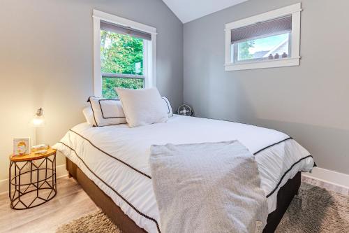 a bedroom with a bed and two windows at Walk to Dtwn Charlevoix Condo with Fireplace in Charlevoix