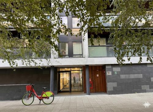 a red bike parked in front of a building at Apartment Lux Stratford London in London