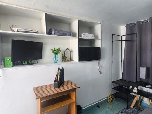 a living room with a tv and a table at La Casona Xalapa, céntrica y lugar muy tranquilo in Xalapa
