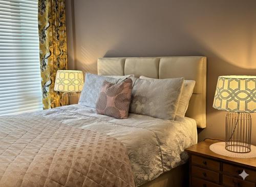a bedroom with a bed with two lamps on it at Apartment Lux Stratford London in London