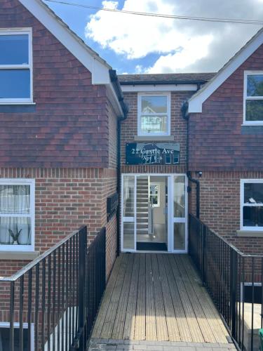 a brick house with a wooden ramp leading to the front door at Dover Ferry Apartments, private terrace and on-site parking in Dover