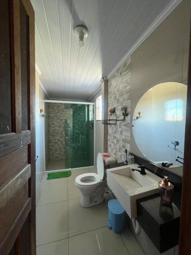 a bathroom with a toilet and a sink and a mirror at Chácara vó Zenilda in Itatiaia