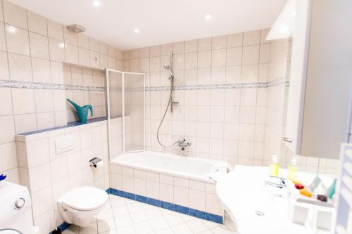 a bathroom with a tub and a toilet and a sink at Ski-n-Lake City Apartments in Zell am See