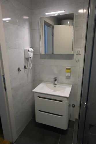 a white bathroom with a sink and a mirror at Riverside Nis in Niš