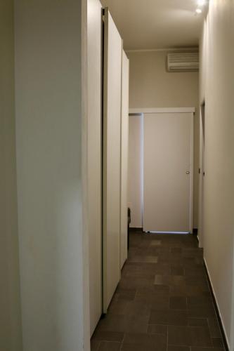 an empty hallway with white walls and tile floors at Casa Gien in Ferrara