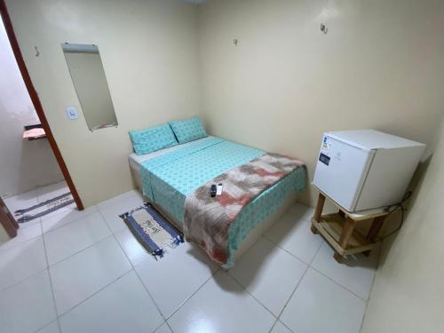 ein kleines Schlafzimmer mit einem Bett und einem kleinen Kühlschrank in der Unterkunft Restaurante e Pousada Belo Paraíso in Belém