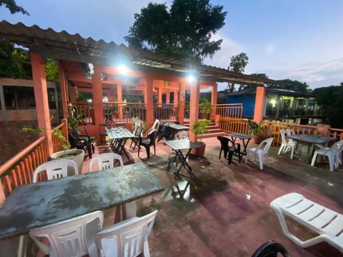 a patio with tables and white chairs and a building at Restaurante e Pousada Belo Paraíso in Belém