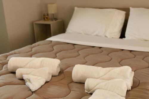 a bed with three towels on the bottom of it at Casa Gien in Ferrara