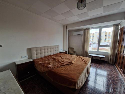 a bedroom with a large bed and a window at Nules historical flat with lift - Pets OK in Nules