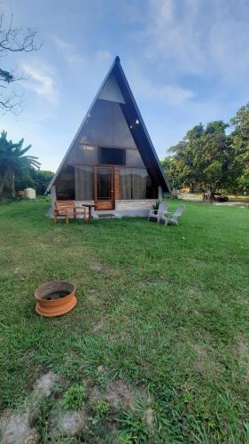 a house with a black roof in a field at Cabaña del Campo in Santa Rosa de Copán