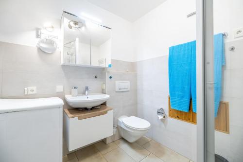 a white bathroom with a sink and a toilet at Ferienwohnungen Christoph in der Edelweißstraße in Pfaffing