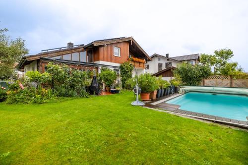 a backyard with a swimming pool and a house at Ferienwohnungen Christoph in der Edelweißstraße in Pfaffing