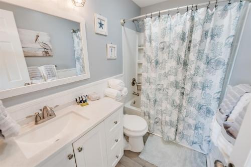 Un baño con lavabo, inodoro y ducha. en North Myrtle's Kings View, 2nd Floor, Great Views!, en Myrtle Beach