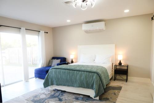 ein Schlafzimmer mit einem Bett und einem blauen Stuhl in der Unterkunft Brand NEW Renovated Coastal Beach House in Naples