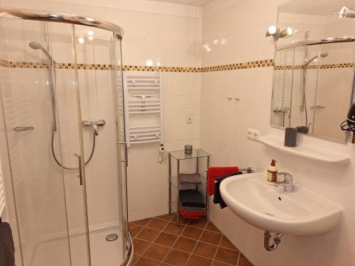 a white bathroom with a sink and a shower at Haus Sternblick in Bischofswiesen