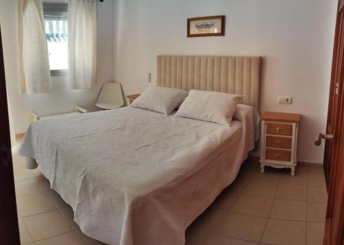 a bedroom with a large bed and a night stand at Dúplex con solárium privado junto al Ayuntamiento de Barbate in Barbate