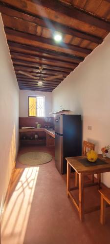 a kitchen with a table and a refrigerator at Villa Katerina - Paje in Paje