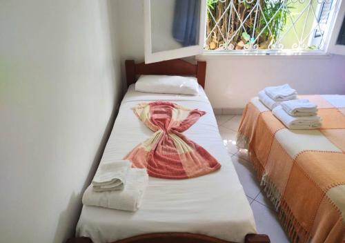 two beds sitting next to each other in a room at Hotel Casa Branca in Guarujá