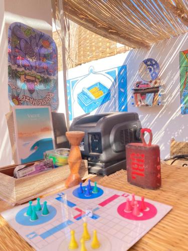 a table with acomputer and toys on it at Bright Wave Surfhouse in Tamraght Ouzdar
