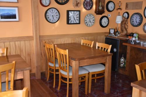 a dining room with clocks on the wall at Asói Hostal in Puerto Natales