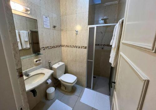 a bathroom with a sink and a toilet and a shower at Hotel Casa Branca in Guarujá