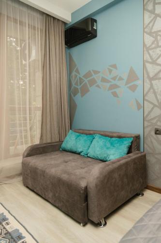 a bedroom with a large bed with a blue wall at Hotel Graif Ti in Tbilisi City
