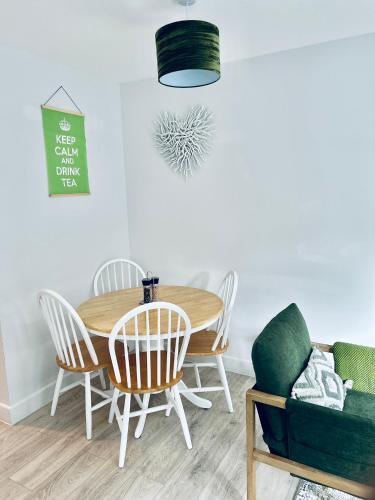 a dining room with a wooden table and chairs at Dover Ferry Apartments, private terrace and on-site parking in Dover