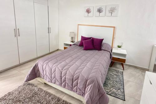 a bedroom with a large bed with purple pillows at Casa Veta Corona Tlalpujahua in Tlalpujahua de Rayón